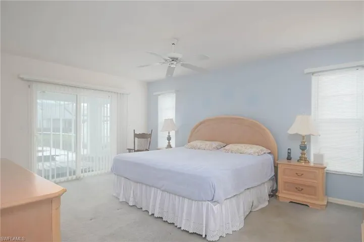 Bedroom featuring light carpet, access to exterior, and ceiling fan