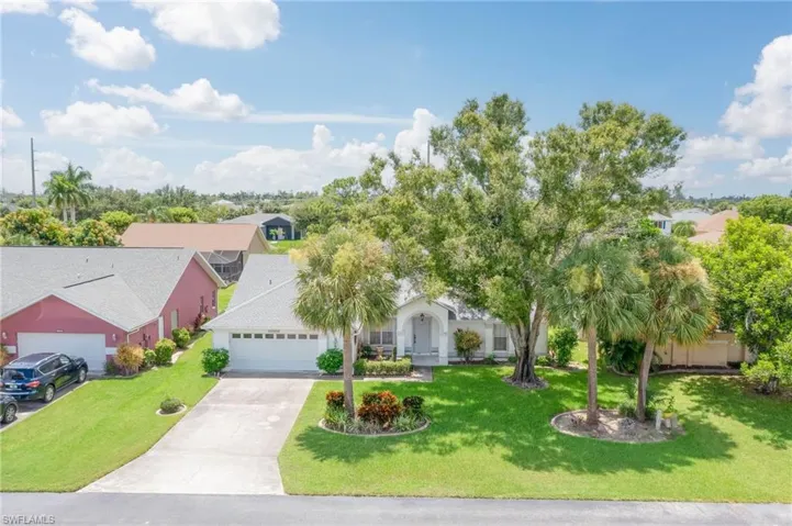 View of front of house with a garage and a front yard