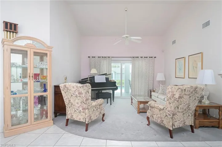 Sitting room with light tile patterned floors, high vaulted ceiling, and ceiling fan