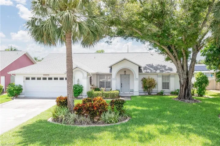 Ranch-style house featuring a garage and a front lawn