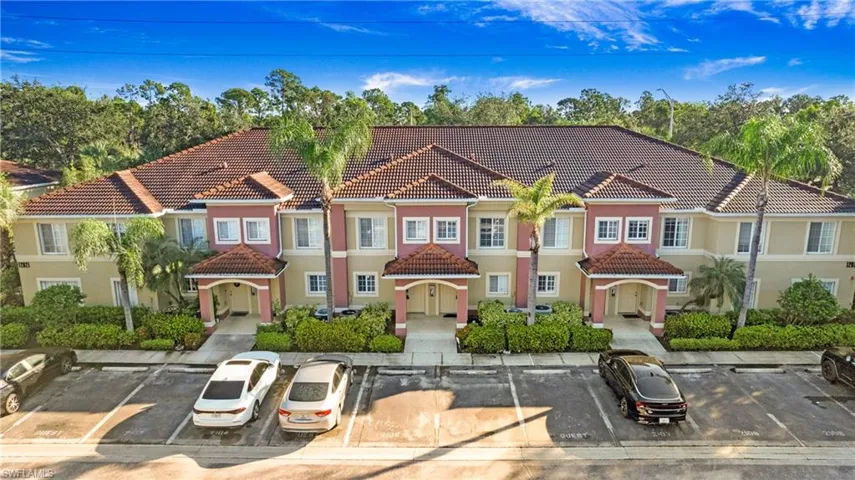 View of front of house with a tiled roof, stucco siding, and uncovered parking