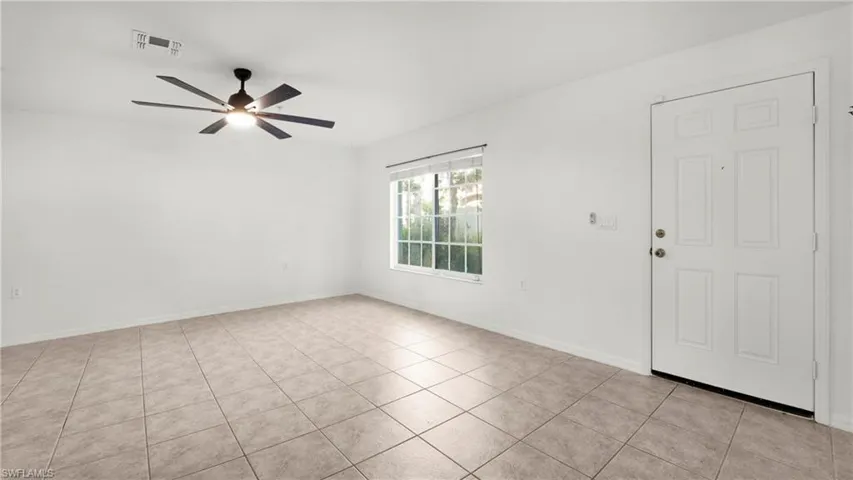 Foyer entrance with light tile patterned flooring and a ceiling fan