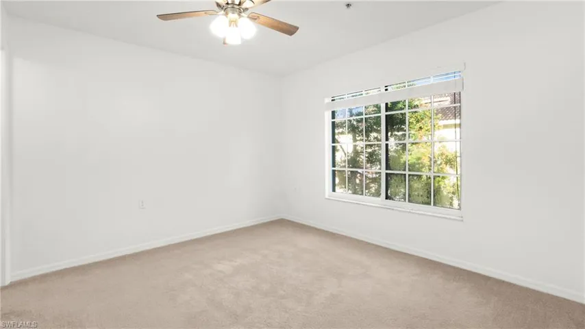 Spare room featuring light carpet and ceiling fan