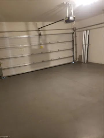 Garage with a garage door opener and concrete block wall