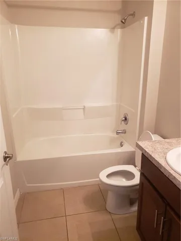 Bathroom featuring light tile patterned floors, tub / shower combination, and vanity