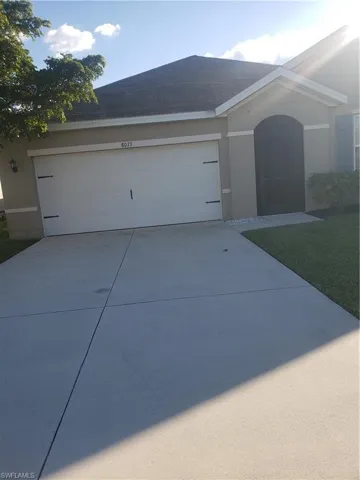 Ranch-style home with concrete driveway, stucco siding, and an attached garage