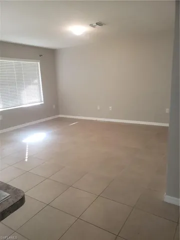 Spare room featuring baseboards and light tile patterned flooring