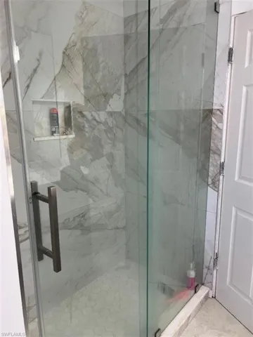 Bathroom featuring a marble finish shower