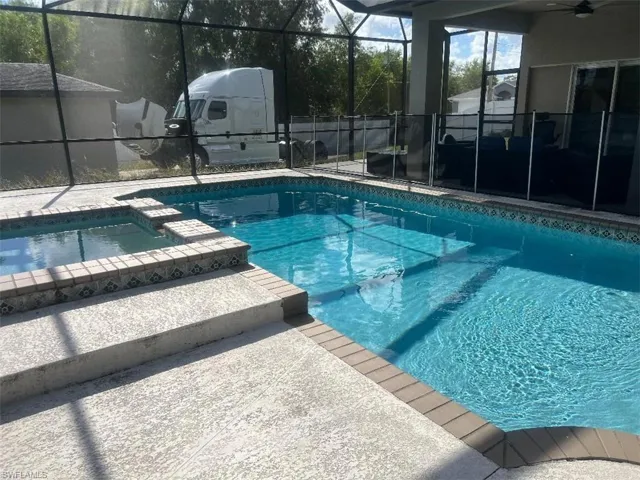 Integrated pool / spa featuring a lanai, a sunroom, and a patio area