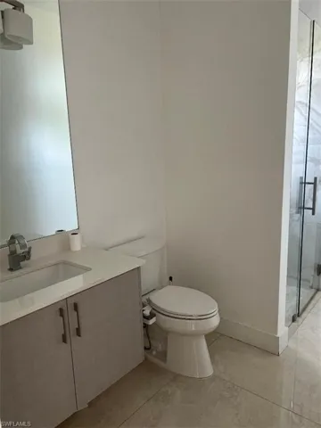 Bathroom featuring vanity, a shower stall, and light tile patterned floors