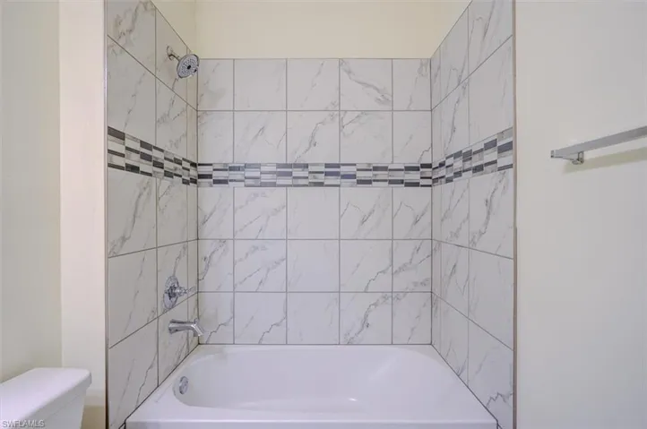 Bathroom with toilet and tiled shower / bath