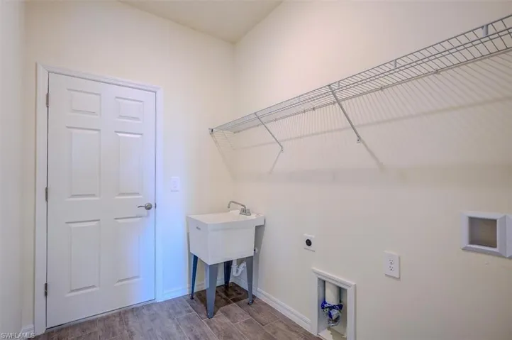 Clothes washing area featuring hookup for an electric dryer and hardwood / wood-style floors