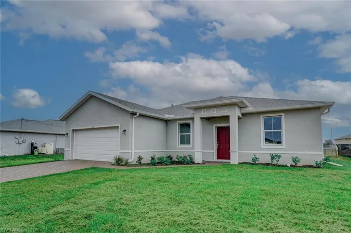 View of front of property featuring a garage and a front lawn