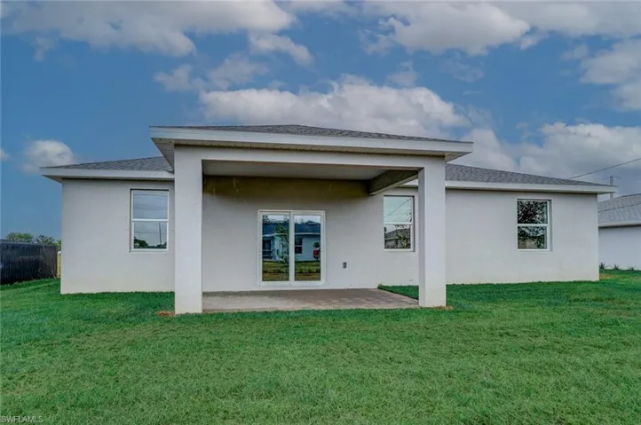 Rear view of house featuring a patio area and a lawn
