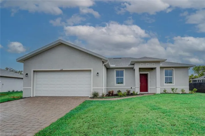 Ranch-style home featuring a garage and a front lawn