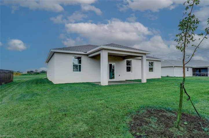 Rear view of property featuring a patio and a lawn