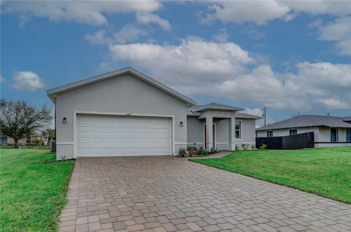 Single story home with central AC, a garage, and a front lawn