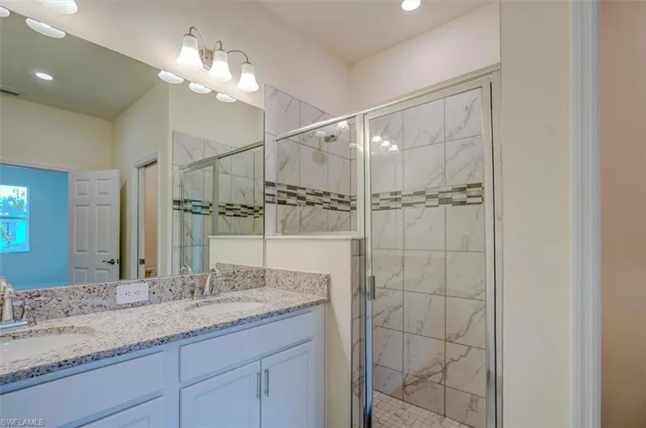 Bathroom featuring vanity and an enclosed shower
