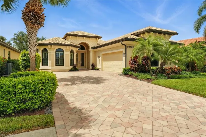 Mediterranean / spanish-style house featuring an attached garage, stucco siding, a tiled roof, and decorative driveway