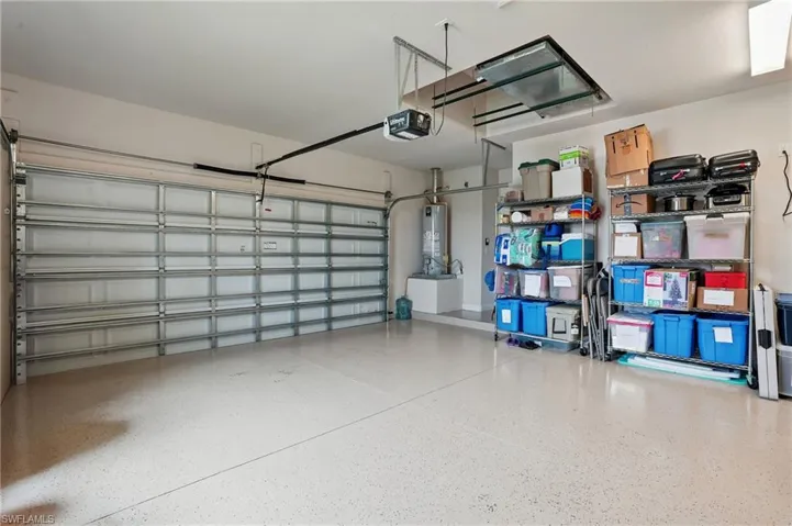 Garage featuring a garage door opener and gas water heater