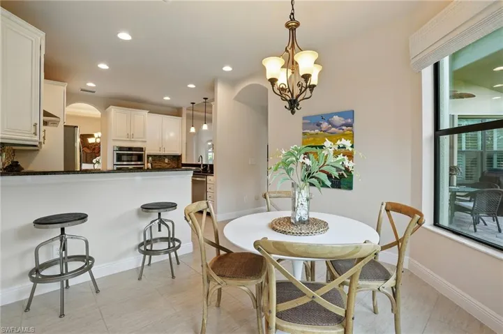 Dining space with arched walkways, recessed lighting, and a chandelier