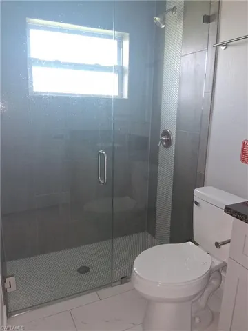 Full bath with a shower stall and vanity
