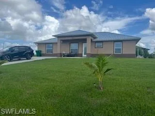 View of front of home featuring a front lawn and stucco siding