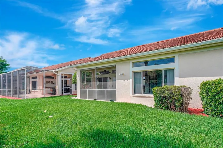 Back of house with a yard, a lanai, ceiling fan, and a patio area
