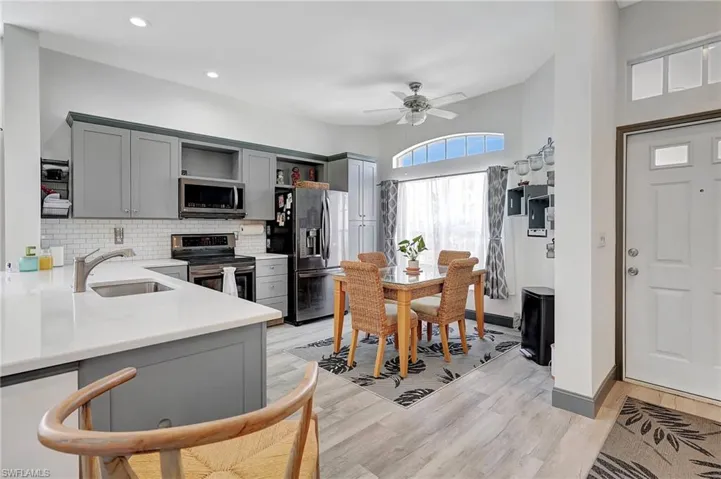 Kitchen with light hardwood / wood-style flooring, appliances with stainless steel finishes, sink, and gray cabinetry