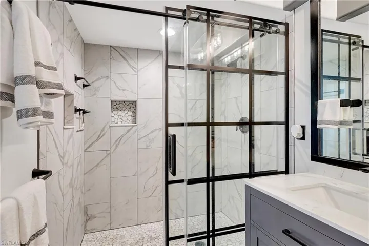 Bathroom with a shower with shower door and vanity