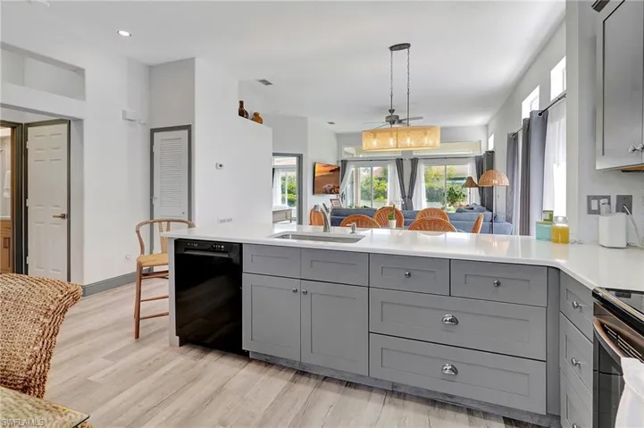 Kitchen featuring sink, kitchen peninsula, light hardwood / wood-style flooring, dishwasher, and gray cabinets