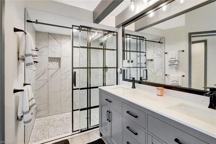 Bathroom with vanity, hardwood / wood-style floors, and a shower with shower door