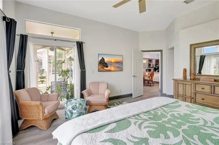 Bedroom with ceiling fan, access to outside, light wood-type flooring, and multiple windows