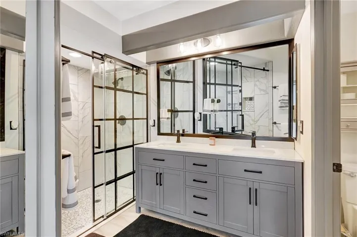 Bathroom featuring a shower with door and vanity