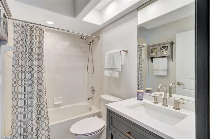 Full bathroom featuring shower / bath combo with shower curtain, vanity, and toilet
