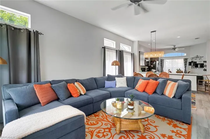 Living room with light hardwood / wood-style flooring, a wealth of natural light, and ceiling fan