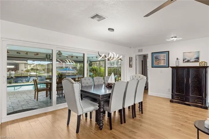 Dining area featuring a textured ceiling, light hardwood / wood-style flooring, and a notable chandelier
