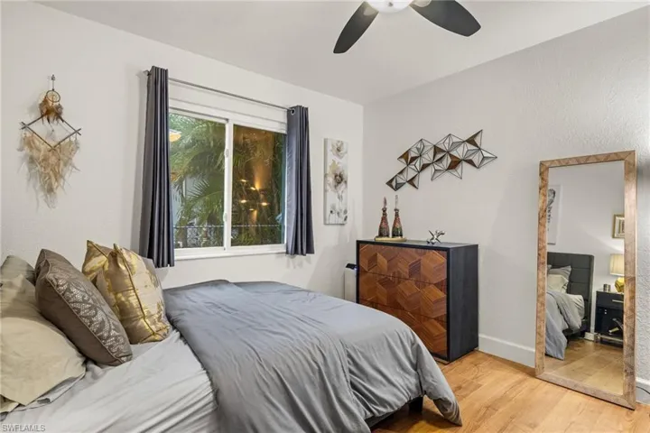 Bedroom with multiple windows, ceiling fan, and light hardwood / wood-style floors