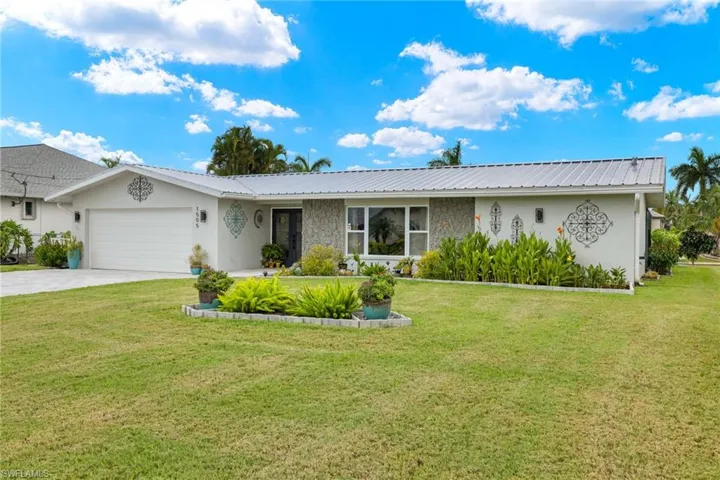 Ranch-style house featuring a garage and a front lawn