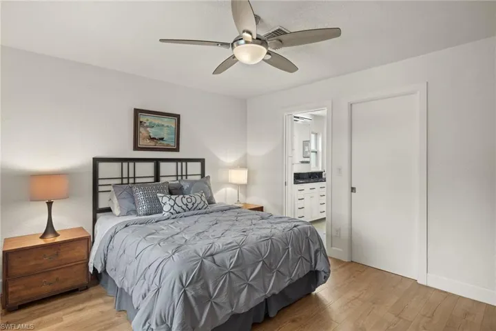 Bedroom featuring ceiling fan, connected bathroom, and light hardwood / wood-style flooring