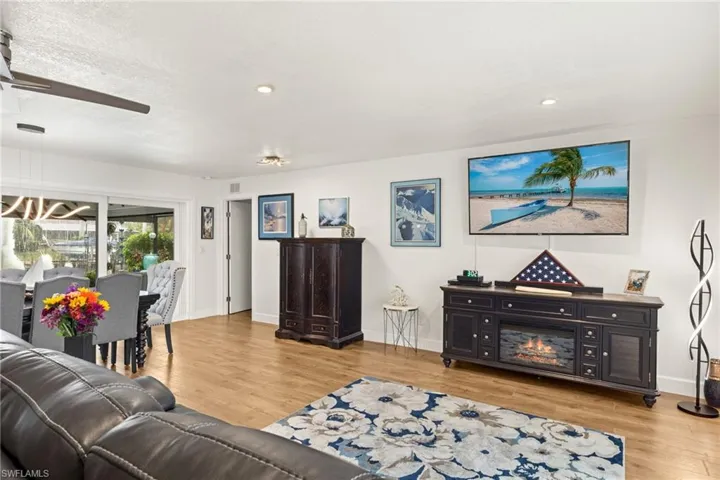 Living room featuring a textured ceiling, ceiling fan, and light hardwood / wood-style floors