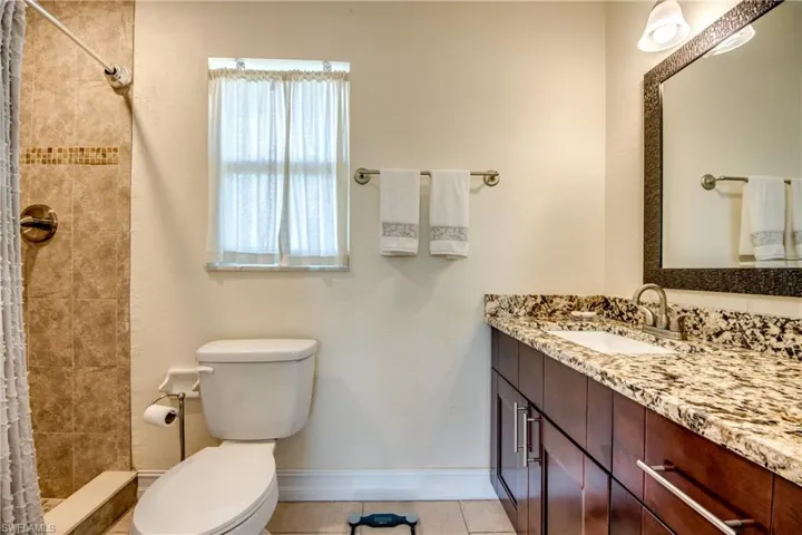 Full bathroom featuring a stall shower, vanity, and light tile patterned flooring