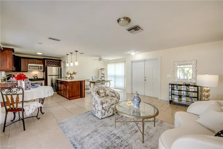Living room with light tile patterned floors and a ceiling fan