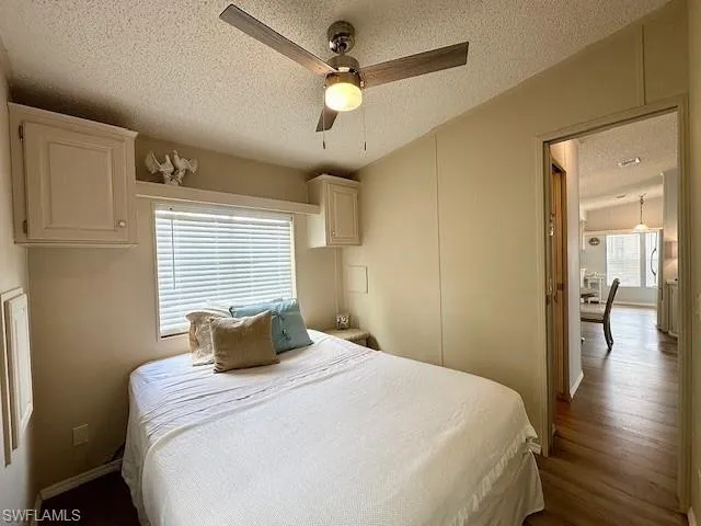 Bedroom featuring a textured ceiling, ceiling fan, and wood-type flooring