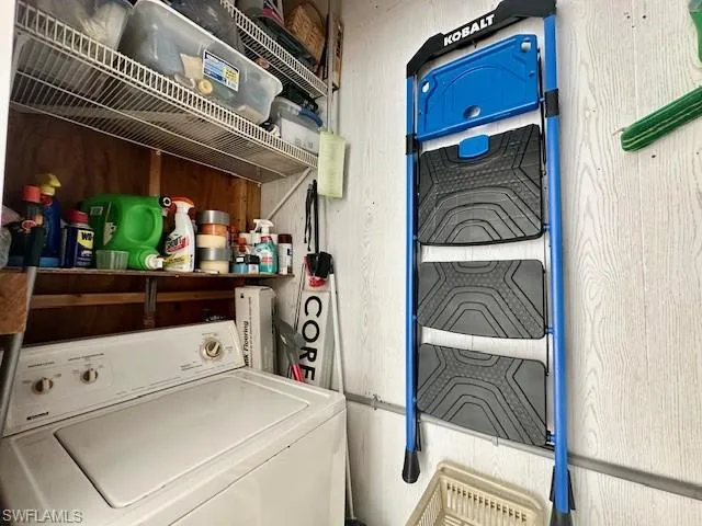 Laundry area with wooden walls and washer / clothes dryer