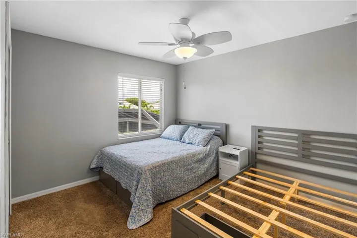Bedroom with dark carpet and ceiling fan