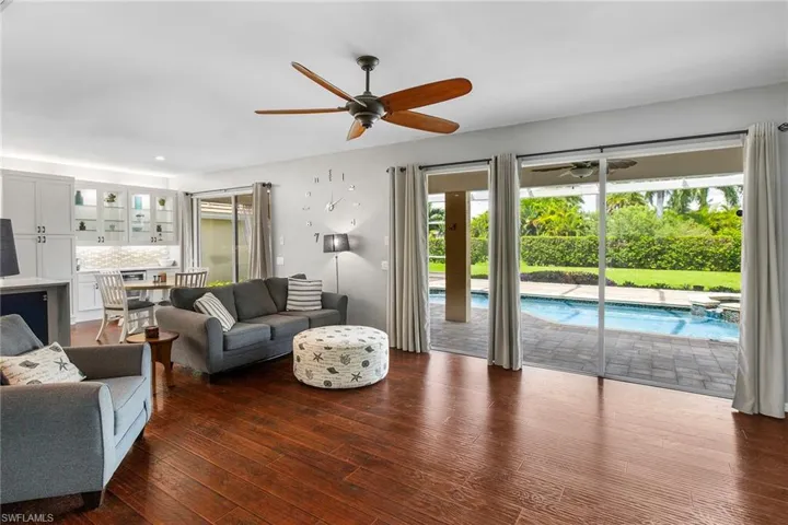 Living room with dark wood-type flooring and ceiling fan