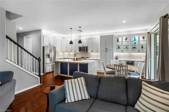 Living room featuring dark wood-type flooring, wine cooler, and sink