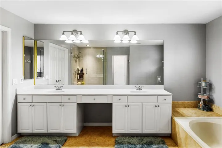 Bathroom featuring plus walk in shower, tile patterned flooring, and vanity