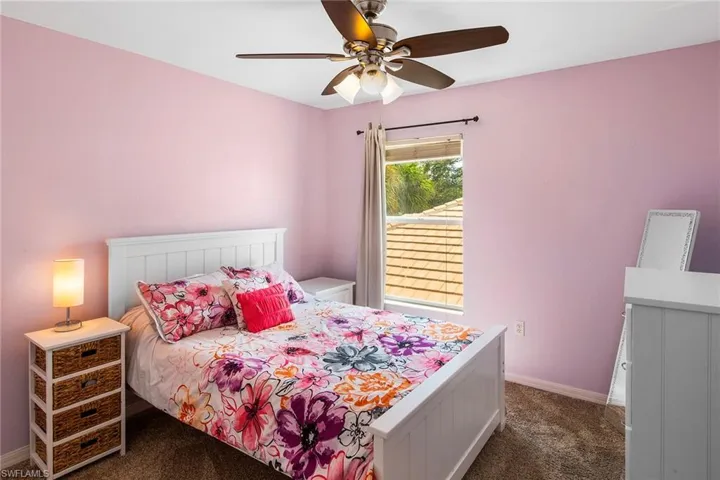 Bedroom with dark colored carpet and ceiling fan